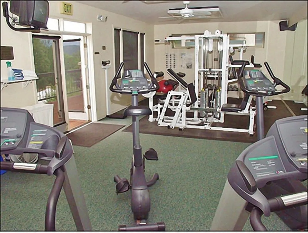 A well-equipped fitness center with treadmills, exercise bikes, and weight training equipment. The room is bright and organized, inviting guests to pursue fitness goals and wellness routines.